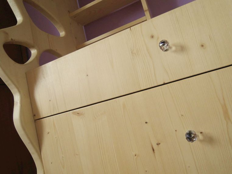 La commode a de jolis petits boutons étincelant comme des diamants.