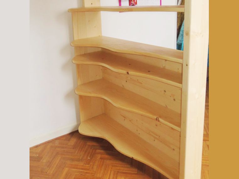 Une petite étagère toute en courbes douces sépare le volume sous le lit, du bureau.