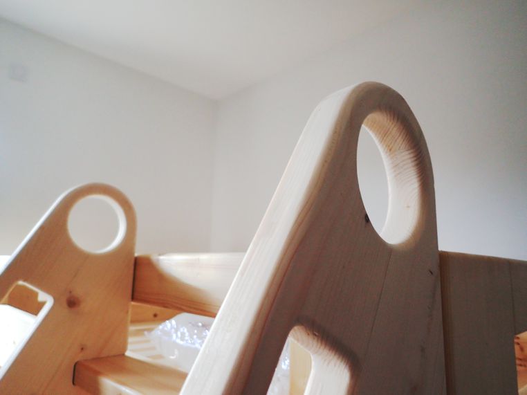 Les poignées rondes du haut permettent d'attraper et de repérer l'escabeau quand on est sur le lit.